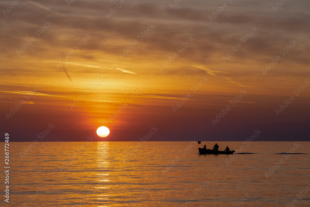 Fishermen in the sea during beautiful sunrise. 