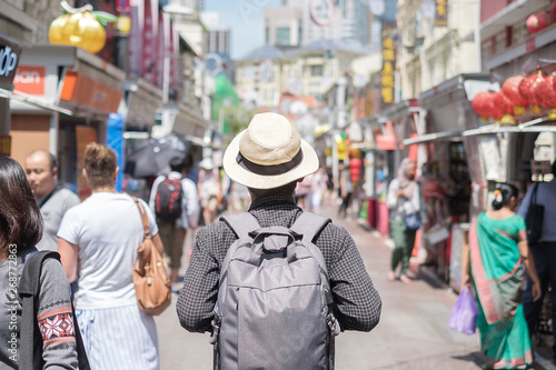 Young man hipster traveling with backpack and hat, happy Solo traveler walking at Chinatown street market in Singapore. landmark and popular for tourist attractions. Southeast Asia Travel concept
