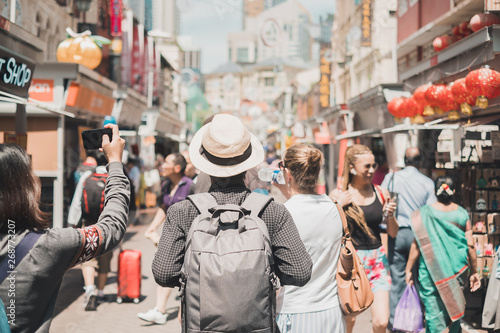 Young man hipster traveling with backpack and hat, happy Solo traveler walking at Chinatown street market in Singapore. landmark and popular for tourist attractions. Southeast Asia Travel concept photo