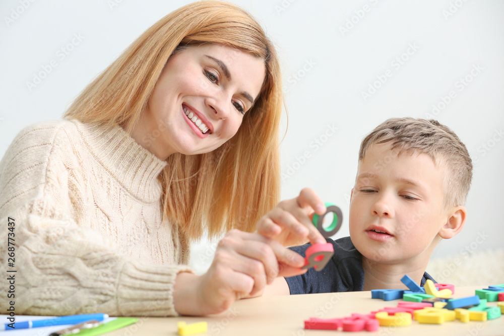 Female psychologist working with boy suffering from autistic disorder Female psychologist working with boy suffering from autistic disorder