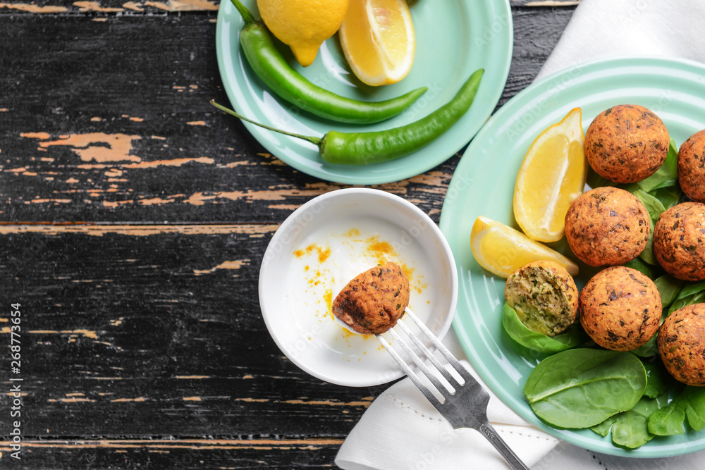 Tasty falafel balls with sauce on wooden table