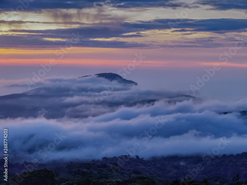 sunrise at Doi Inthanon, mountain view morning of peak mountain Doi Hua Suea around with sea of fog with red sun light in the sky background, KM.41 view point Doi Inthanon, Chiang Mai, Thailand.