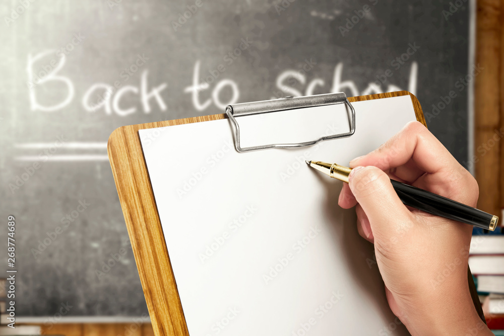 Clipboard Notes Learning Student hands holding clipboard and writing in the classroom with piles ...
