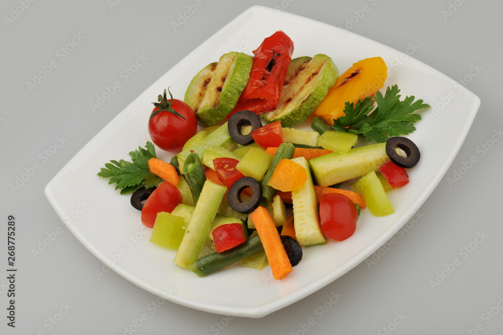 Different green vegetables on the plate gray background