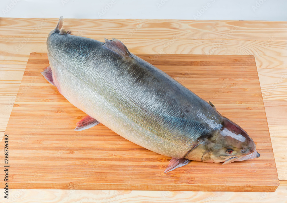 Fresh uncooked arctic char on a wooden cutting board