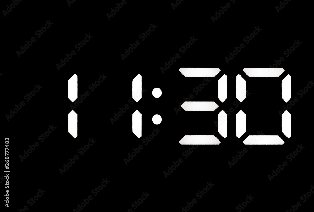 Real white led digital clock on black background