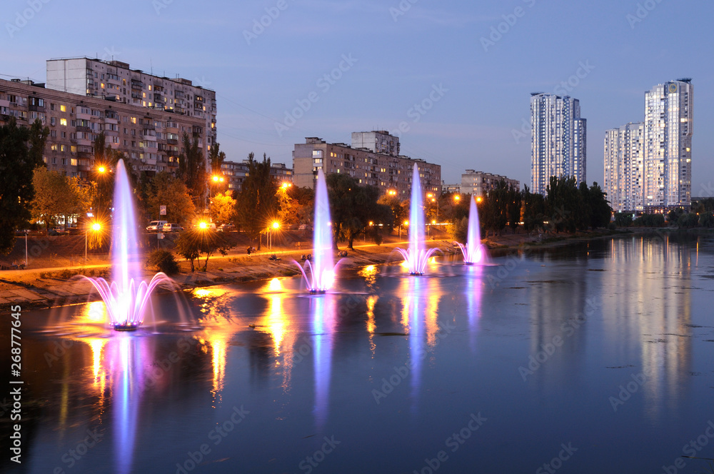 Obraz premium View of the Pusanovka lake and illuminated fountains working. May 5, 2019. Kiev, Ukraine