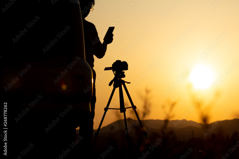 夕焼け空を撮影している男性カメラマン