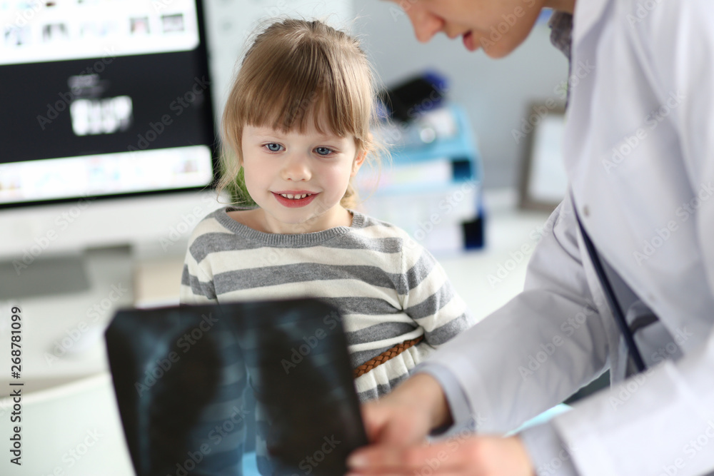 Fototapeta Female paediatrician working with cute little girl at her office explaining diagnosis to her portrait
