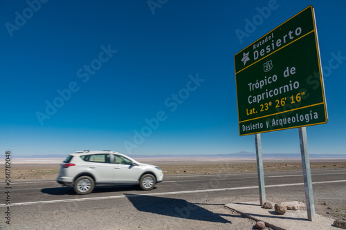 Tropic of Capricorn sign and blurred car in Atacama Desert, Chile - South America