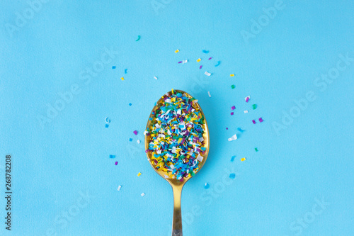 Microplastic in a spoon on blue background. microplastic in water and food. Microplastic problem. Dangerous additives. Toxic substances. photo