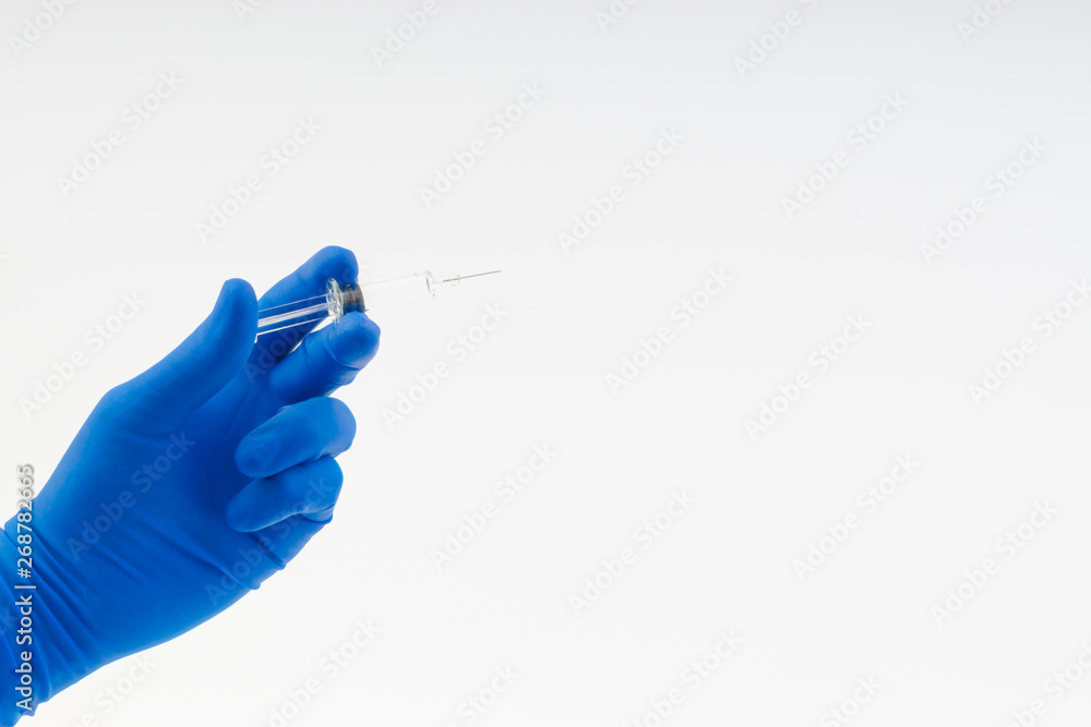 Hand in a blue glove holding syringe isolated on white Hand in a blue glove holding syringe isolated on white