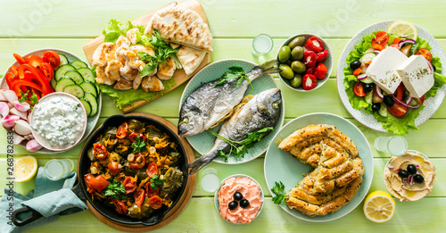 Selection of traditional greek food - salad  meze  pie  fish  tzatziki  dolma on wood background  top view