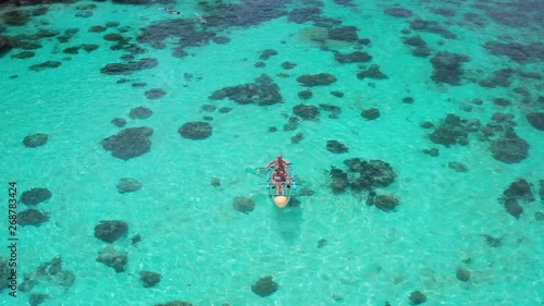 Aerial drone view of couple with dog in kayak over amazing crystal clear sea water