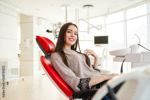 Beautiful girl in red dental chair. photo