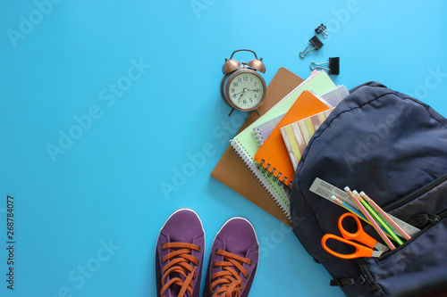 Backpack and supplies school on blue background. Back to school concept. Top view.