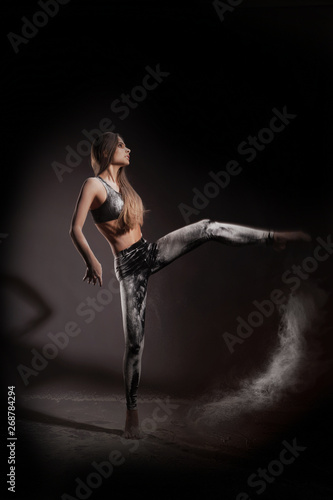 Girl dansing with flour on black background one person