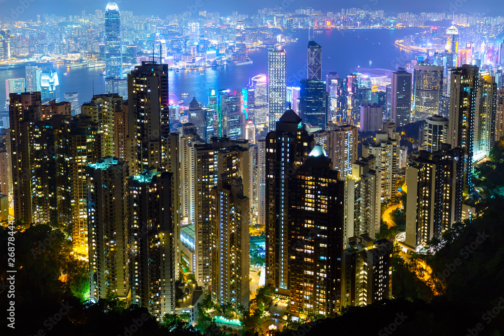 Naklejka premium The most famous view of Hong Kong at twilight sunset. Hong Kong skyscrapers skyline cityscape view from Victoria Peak illuminated in the evening. Hong Kong, special administrative region in China.