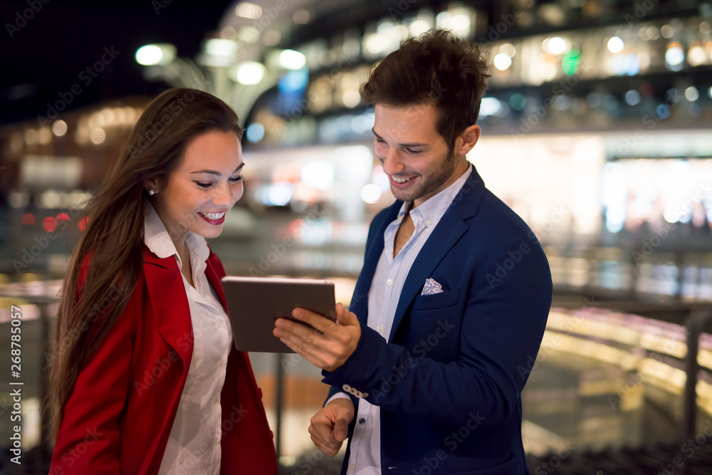 People using tablet at night in a city