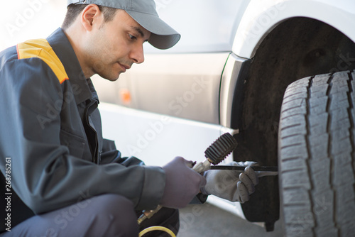 Quadro su tela Mechanic checking the pressure of a van tire