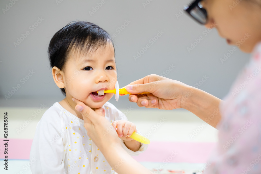 Mother is brushing her daughter teeth. Asian baby girl toothbrush by her mom. Mother is brushing her daughter teeth. Asian baby girl toothbrush by her mom.