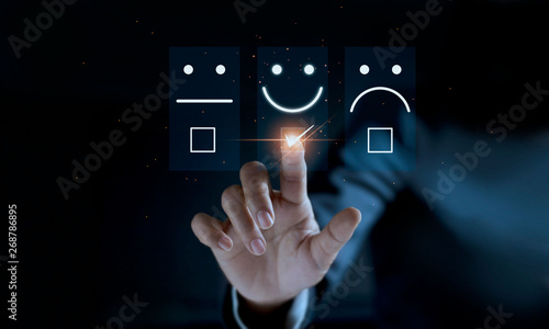 Finger of businessman touching and check mark icon face emoticon smile on dark background, service mind, service rating. Satisfaction and customer service concept photo