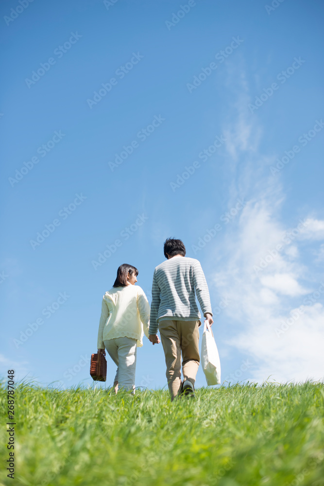 草原を歩くカップルの後姿