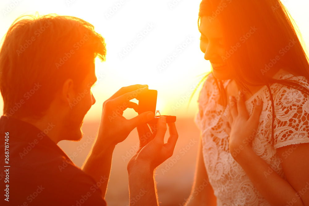 Silhouette of a marriage proposal at sunset - obrazy, fototapety, plakaty 
