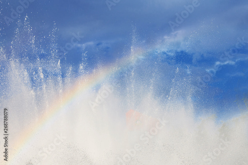 fountain with a rainbow against the blue sky