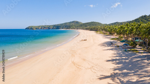 Wide tropical beach with white sand and small islands, top view. Nacpan Beach El Nido, Palawan. Seascape in clear weather, view from above. © Tatiana Nurieva
