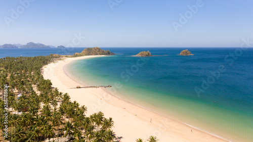 Wide tropical beach with white sand and small islands, top view. Nacpan Beach El Nido, Palawan. Seascape in clear weather, view from above.
