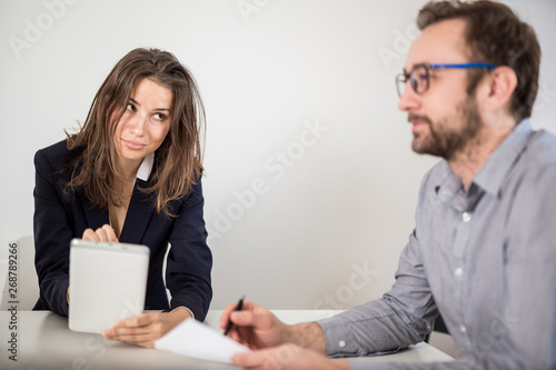 Angry female boss on a business meeting with her male colleague.