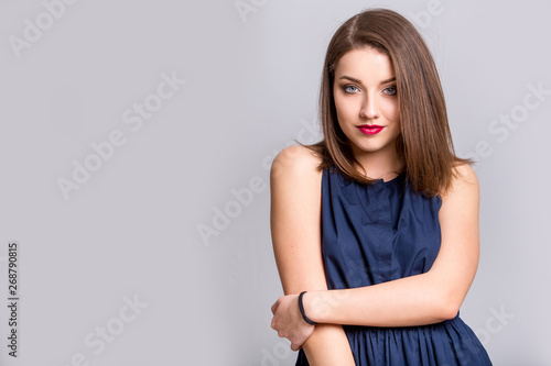oung beautiful woman with long hair wearing blue dress happy smiling