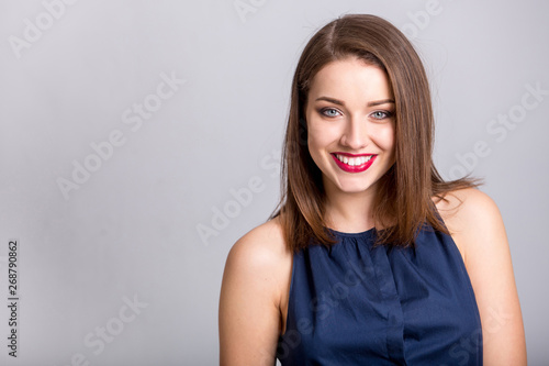 oung beautiful woman with long hair wearing blue dress happy smiling