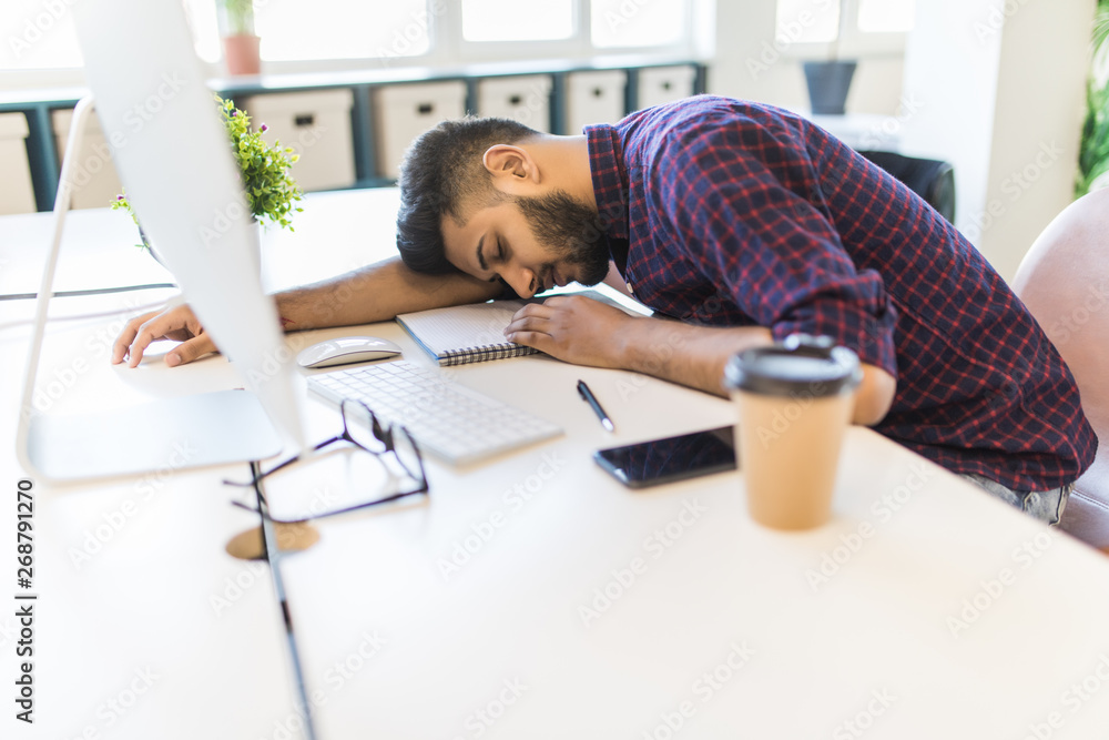 Office man sleeping while working on the computer in modern office Office man sleeping while working on the computer in modern office
