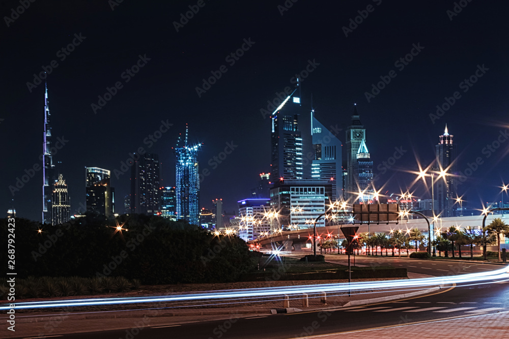 Fototapeta premium Night landscape with views of the skyscrapers and the Burj Khalifa from the side of the road