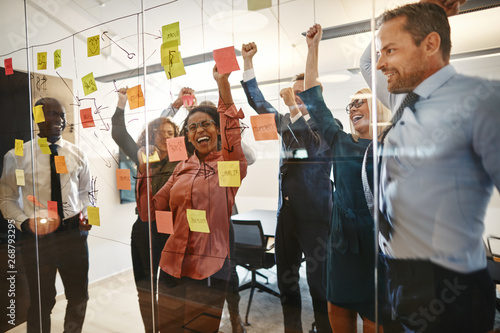 Excited businesspeople cheering together after an office brainst