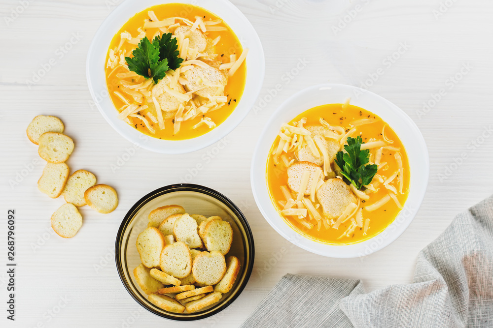 Pumpkin cream soup with croutons and fresh dill and parsley on wooden background, top view Pumpkin cream soup with croutons and fresh dill and parsley on wooden background, top view