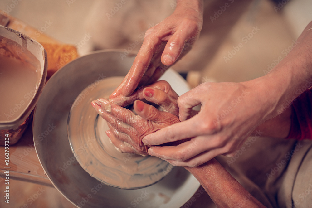 Top view of female hands in clay