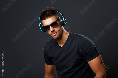 Handsome man with headphones in studio on dark background © djile