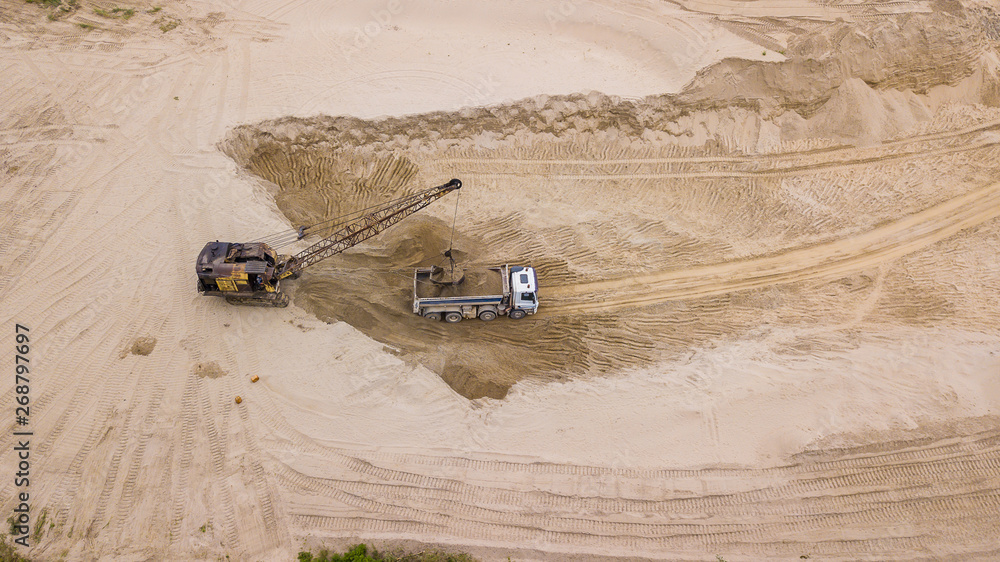 Tod down view of excavator and dump truck. On the construction site. Tod down view of excavator and dump truck. On the construction site.