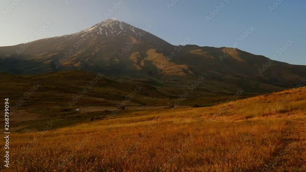 A panning shot of Damavand's snowy peak during summer and extended field 3 A 4K following shot of foothill of Damavand's peak summer sunlight and plants shaking by wind yellow and blue colored A panning shot of Damavand's snowy peak during summer and extended field 3 A 4K following shot of foothill of Damavand's peak summer sunlight and plants shaking by wind yellow and blue colored