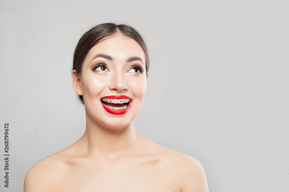 Beautiful smiling woman in braces on white. Happy girl with braces portrait Beautiful smiling woman in braces on white. Happy girl with braces portrait
