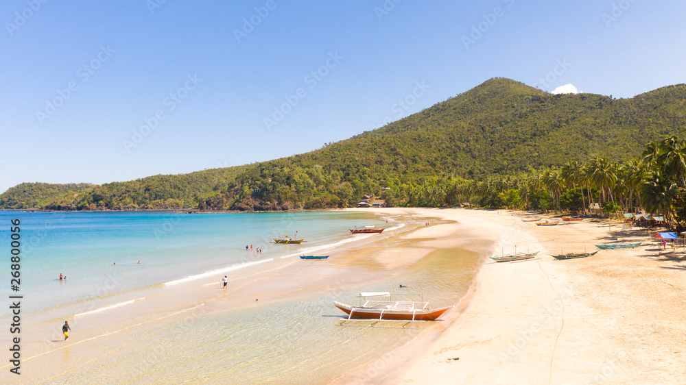Tropical white beach and warm lagoon.Boats and tourists on the shore of the island.Seascape, view from above.