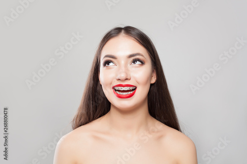 Happy young woman in braces smiling on white background. Pretty girl with braces having fun
