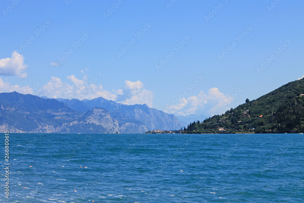 Summer landscape on lake Garda Italy with turquoise water and green mountains on the banks