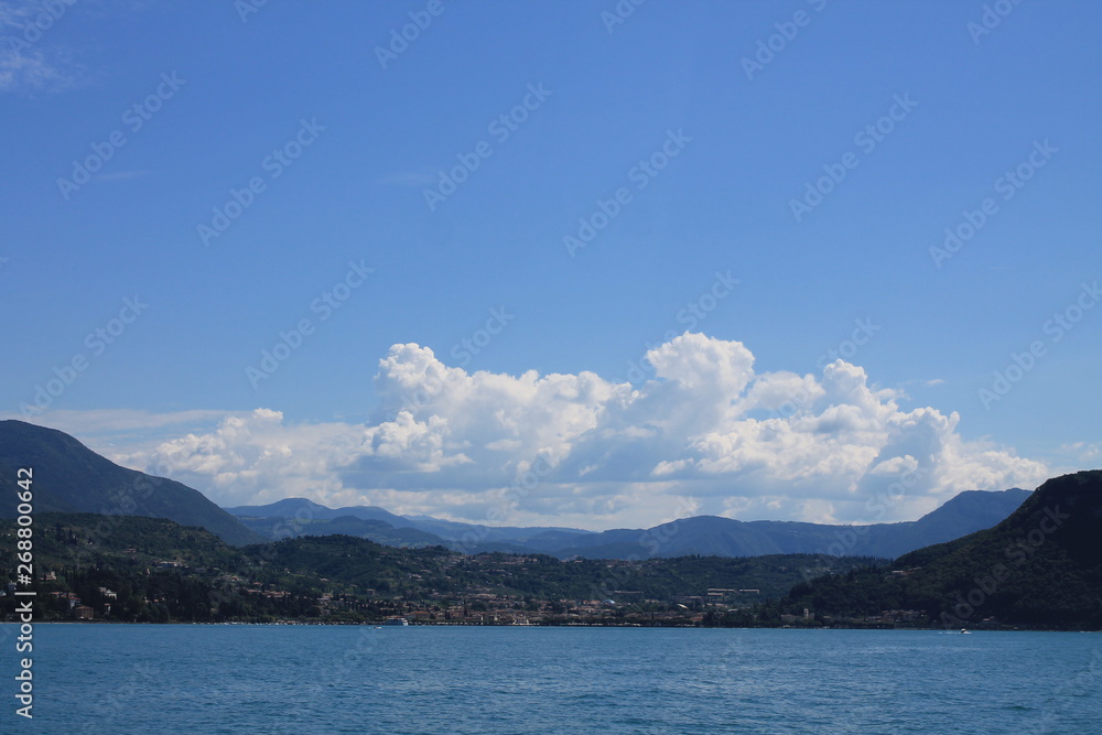 Summer landscape on lake Garda Italy with turquoise water and green mountains on the banks Summer landscape on lake Garda Italy with turquoise water and green mountains on the banks