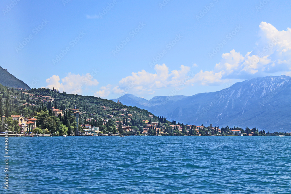 Summer landscape on lake Garda Italy with turquoise water medieval town on a green hill