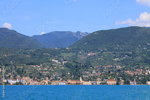 Summer landscape on lake Garda Italy with turquoise water medieval town on a green hill