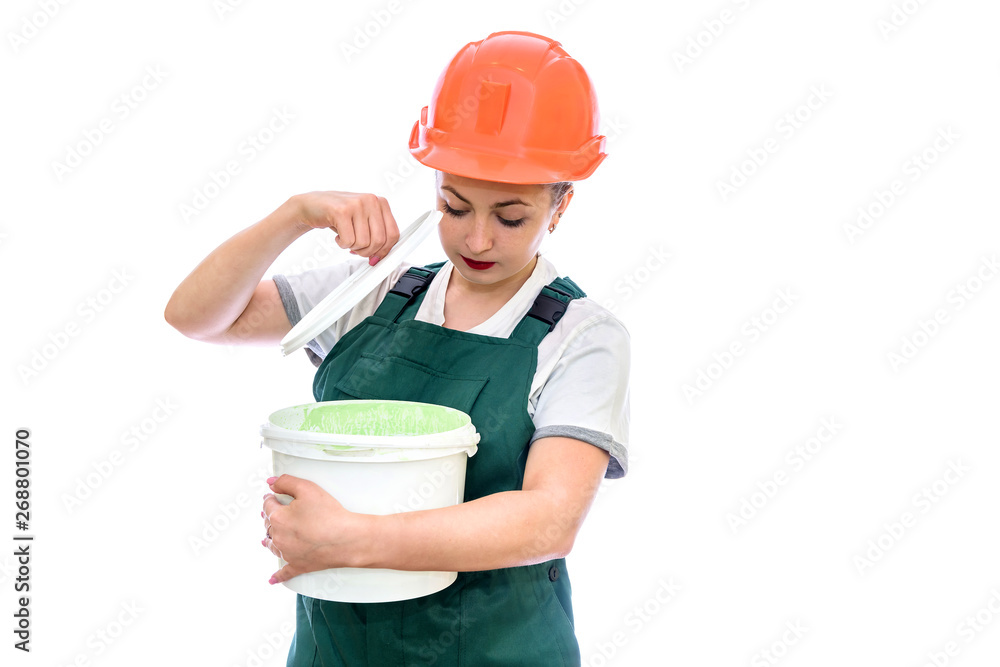 Woman in helmet with paint bucket isolated on white Woman in helmet with paint bucket isolated on white